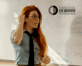 Teacher with glasses looking at board