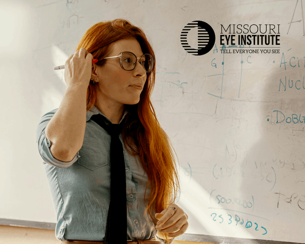 Teacher with glasses looking at board
