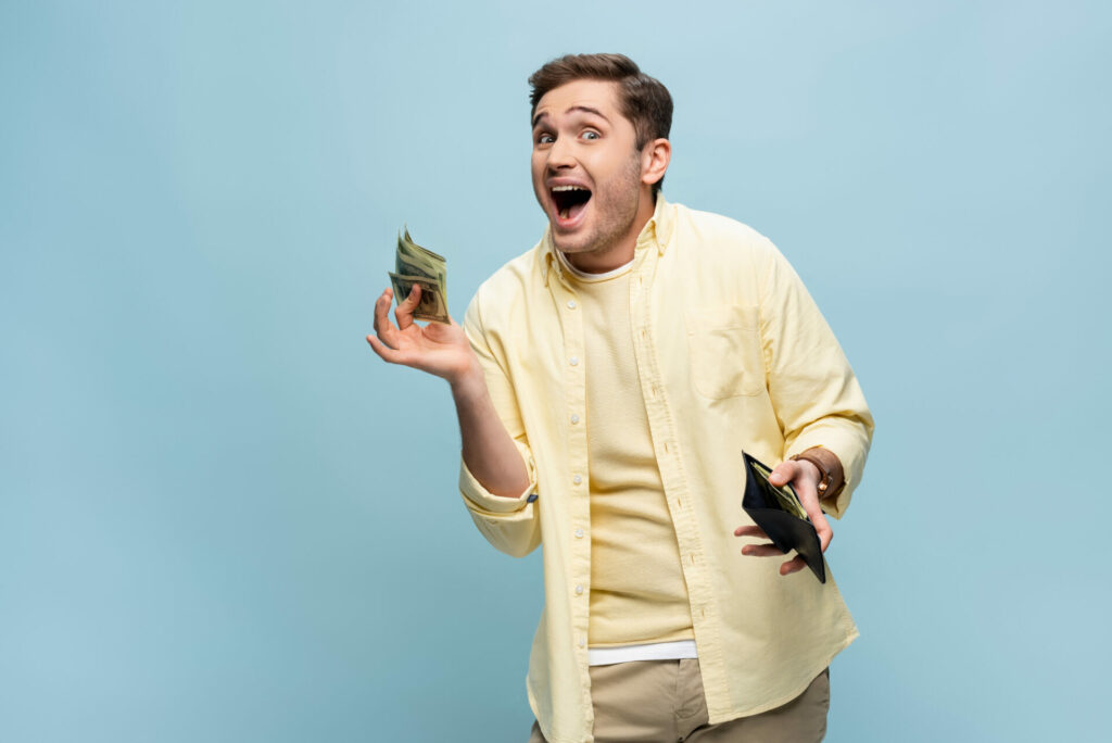 Excited young man holding money