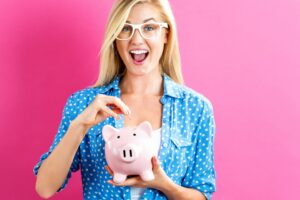 woman putting money in piggy bank